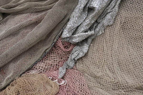 a heap of pastle pink, silver and gray colored fishing nets