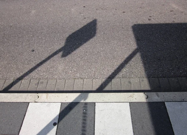 Cień znaku przystanku autobusowego na asfaltowej drodze — Zdjęcie stockowe