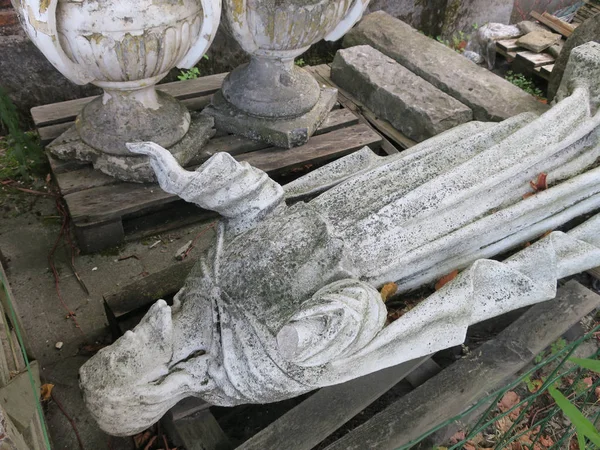 Сломанная статуя святого, лежащего в саду — стоковое фото