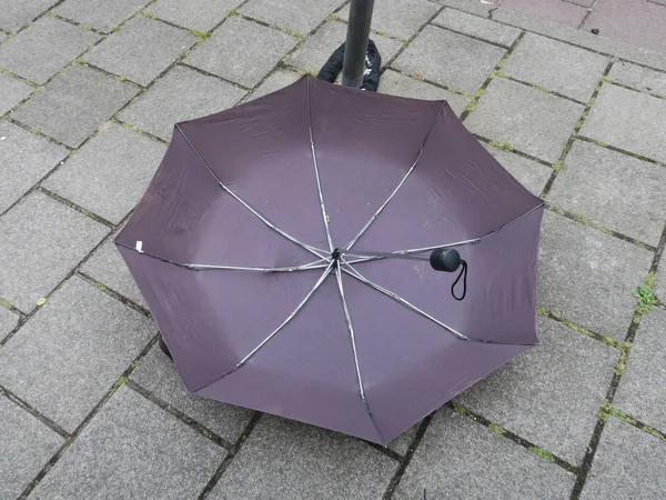 Otoño: paraguas negro roto colocando dowm en la acera — Foto de Stock