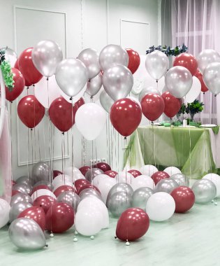 The studio is decorated with a professional design with the use of helium balloons of white, red and silver colors. Beautiful contrasting combination for a photosession of lovers clipart
