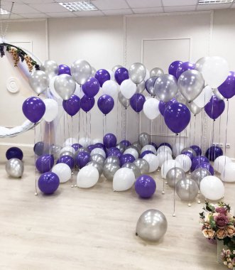 Fotoğraf stüdyosu, beyaz, gümüş ve mor helyum balonları ile dekore edilmiştir. Güzel, yaratıcı ve özgün