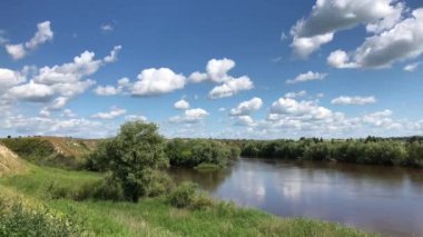 Güzel kümülüs beyaz bulutlar üzerinde parlak mavi gökyüzü ve onları altında nehri Om ve rüzgardan sallanan ağaçların float. Rus expanses. Sibirya