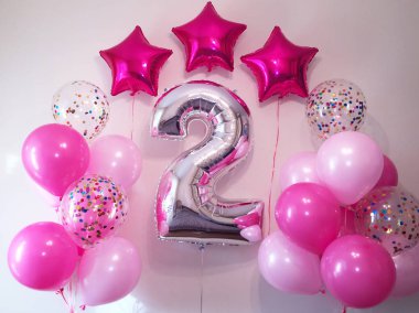 Pembe, konfeti, pembe kalpler, simli yıldızlar ve büyük bir iki figür ile şeffaf kompozisyon helyum balonlar. Küçük bir kız için bir hediye