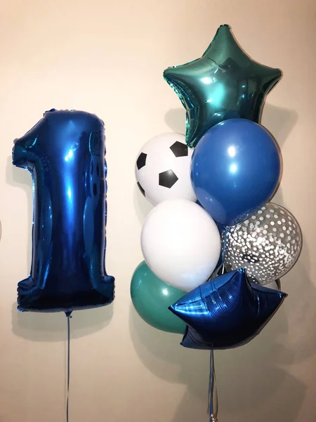Composition of balloons of blue, turquoise and white colors, as well as a large number one blue. Boy\'s birthday present