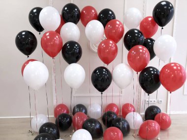 Kompozisyon helyum balon içinde siyah, kırmızı ve beyaz. Fotoğraf oturumu için dekore edilmiş Oda