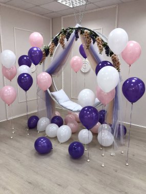 Pembe, mor ve beyaz renk kompozisyonu helyum balonları. Fotoğraf oturumu için dekore edilmiş Oda