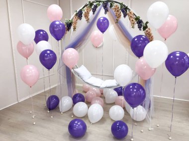 Pembe, mor ve beyaz renk kompozisyonu helyum balonları. Fotoğraf oturumu için dekore edilmiş Oda