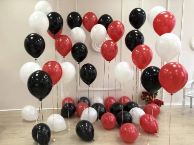 Kompozisyon helyum balon içinde siyah, kırmızı ve beyaz. Fotoğraf oturumu için dekore edilmiş Oda