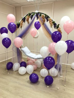 Pembe, mor ve beyaz renk kompozisyonu helyum balonları. Fotoğraf oturumu için dekore edilmiş Oda