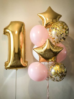 Beyaz, pembe, konfeti, şeffaf yanı sıra altın yıldız ve büyük bir rakam bir altın renk kompozisyonu helyum balonlar. 1 yaşındaki bir kız için hediye