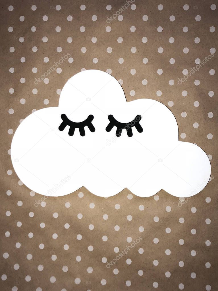 White cloud with black eyelashes on a light brown background with white polka dots