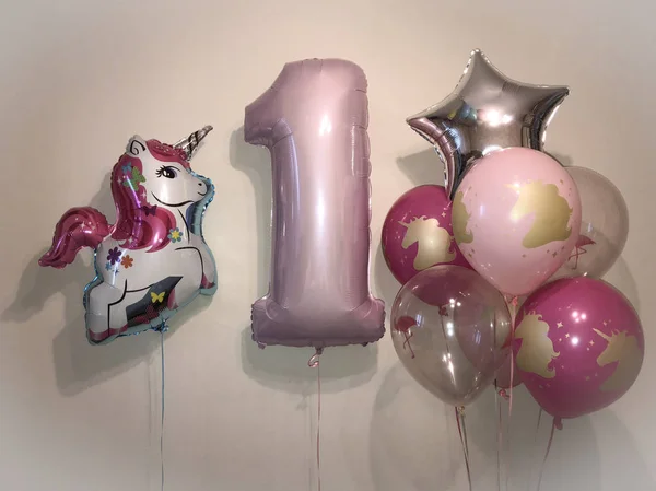 Composition of helium balloons pink, fuchsia, transparent color with the image of a uniform and a balloon in the form of numbers one gently pink color