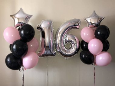 Helyum balonları kompozisyon siyah, pembe, yanı sıra bir gümüş yıldız ve on altı gümüş renklerin büyük bir rakam. Bir kız için 16 yıl hediye