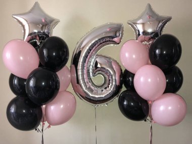 Kompozisyon helyum balonlar siyah, pembe, yanı sıra bir gümüş yıldız ve altı gümüş renklerde büyük bir rakam. 6 yıl boyunca kıza bir hediye