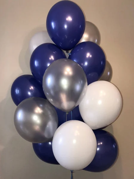 Bright composition of helium balloons in white, blue and silver. Decoration for the boy\'s room for the holiday