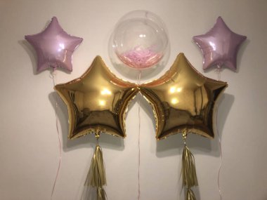 Büyük altın yıldız, soluk pembe yıldızlar ve güzel pembe tüyleri ile hasta bir kabarcık şeklinde helyum balonları Kompozisyon. Tasarımcı Partisi Şenlikli Dekorasyon