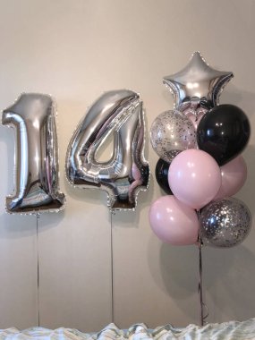 On dört - soluk pembe, gümüş, siyah, gümüş konfeti, gümüş yıldız ve büyük sayılar ile balonlar sarlak balonlar kompozisyonu. On dört kutlama için oda dekorasyonu