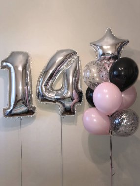 On dört - soluk pembe, gümüş, siyah, gümüş konfeti, gümüş yıldız ve büyük sayılar ile balonlar sarlak balonlar kompozisyonu. On dördüncü yıldönümü kutlamaları için oda dekorasyonu