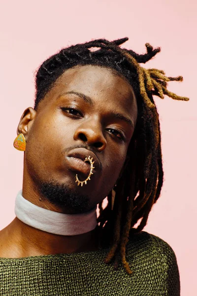 Yeşil pembe üzerinde izole dreadlocks ile genç bir adam portresi