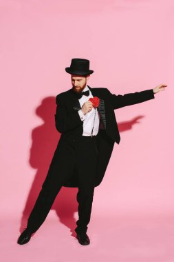 adam bir smokin ve silindir şapka kırmızı bir kalp tutan dans