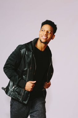 Mutlu genç adam gri studio arka plan üzerinde izole yan isteyen büyük bir gülümseme ile