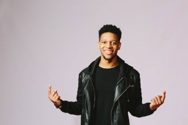 Yukarı dönük iki eliyle serin gülümseyen adam. Çok mutlu