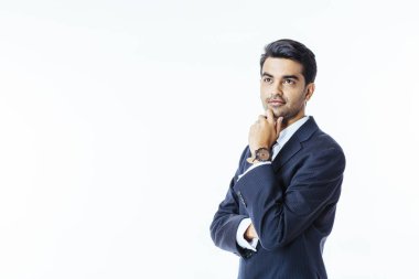 Kendinden emin bir işadamı portresi uygun ve chin, beyaz stüdyo arka plan üzerinde izole ilgiyle, silah çarpı işareti ile yukarıya bakıp bir yandan bağla