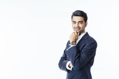 Kendinden emin bir gülümseyen iş adamı chinin takım elbise ve kravat kamera, beyaz stüdyo arka plan üzerinde izole bakarak üzerinde el ile portresi