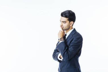 Yakışıklı bir işadamı portresi takım elbise ve kravat ağzı üzerinde el ile düşünme ve beyaz stüdyo arka plan üzerinde izole yan isteyen