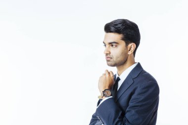 Yakışıklı bir işadamı portresi takım elbise ve kravat ağzı üzerinde el ile düşünme ve beyaz stüdyo arka plan üzerinde izole yan isteyen