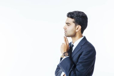 Takım elbiseli bir yakışıklı işadamı portresi profil ve çene üzerinde el ile düşünme ve beyaz stüdyo arka plan üzerinde izole yan bakan kravat