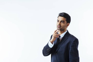 Çenesini bir parmak ile iyi görünümlü bir işadamı portresi. Beyaz arka plan üzerinde izole