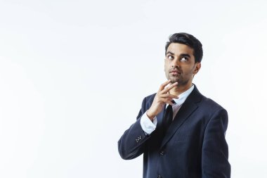 Çenesini bir parmak ile iyi görünümlü bir işadamı portresi. Beyaz arka plan üzerinde izole