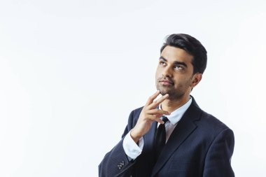 Çenesini bir parmak ile iyi görünümlü bir işadamı portresi. Beyaz arka plan üzerinde izole