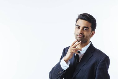 Çenesini bir parmak ile iyi görünümlü bir işadamı portresi. Beyaz arka plan üzerinde izole