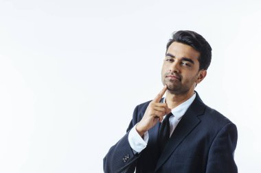 Çenesini bir parmak ile iyi görünümlü bir işadamı portresi. Beyaz arka plan üzerinde izole