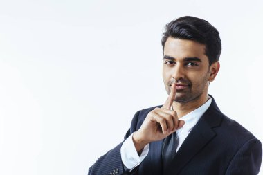 Onun dudağında tek parmakla iyi görünümlü bir işadamı portresi. Beyaz arka plan üzerinde izole