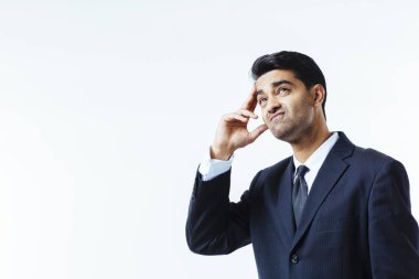 Yakışıklı bir işadamı portresi güvensizlik, acı içinde kafasını tutarak veya meditasyon, izole beyaz arka plan üzerinde