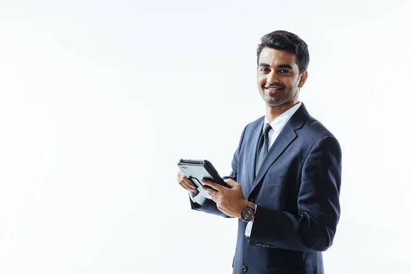 İş adam portresi elektronik tablet pad tutan takım elbise ve beyaz arka plan üzerinde kameraya, gülümseyen izole