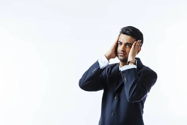 Portrait of a cool businessman holding his head in disbelief or in pain, isolated on white background
