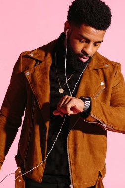 Sakallı, müzik dinlemek, izlemek, pembe studio arka plan üzerinde izole bakarak serin Afrikalı-Amerikalı adam