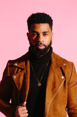 Kamera, pembe studio arka plan üzerinde izole bakarak eğlenceli, yakışıklı ve serin Afro-Amerikan sakallı adam,