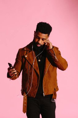 Pembe studio arka plan üzerinde izole müzik, manifatura, dinlemek, yakışıklı, şık ve serin Afro-Amerikan sakallı adam,