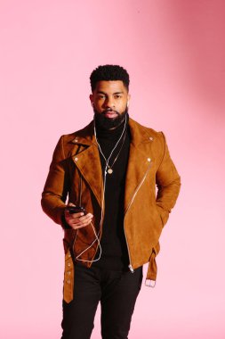 Pembe studio arka plan üzerinde izole müzik, manifatura, dinlemek, yakışıklı, şık ve serin Afro-Amerikan sakallı adam,