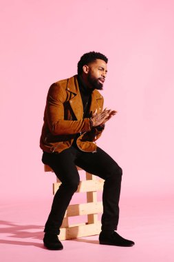 Pembe studio arka plan üzerinde izole sakallı, yakışıklı, şık ve serin Afrikalı-Amerikalı adam