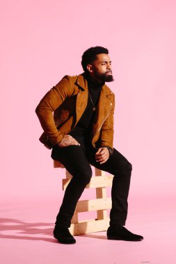 Pembe studio arka plan üzerinde izole sakallı, yakışıklı, şık ve serin Afrikalı-Amerikalı adam