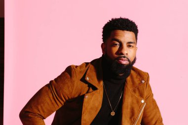 Pembe studio arka plan üzerinde izole sakallı, yakışıklı, şık ve serin Afrikalı-Amerikalı adam