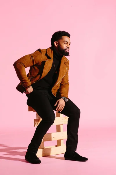 Pembe studio arka plan üzerinde izole sakallı, yakışıklı, şık ve serin Afrikalı-Amerikalı adam