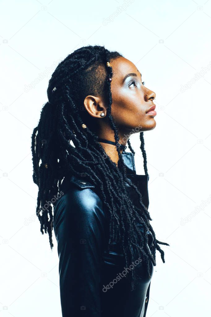 Profile of a woman with in black latex top and long dreadlocks looking up, against white background